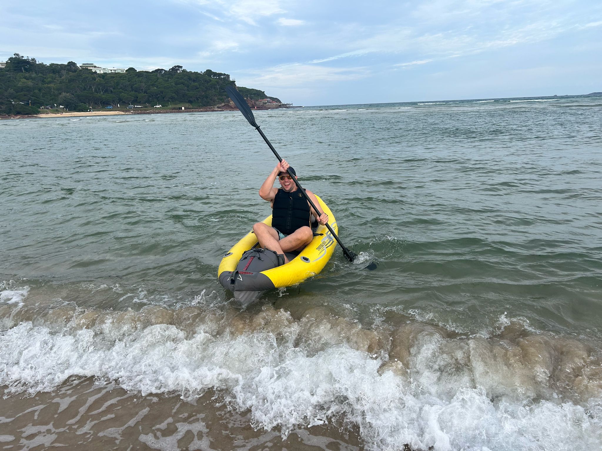 Person in an inflatable kayak in the surf near the beach