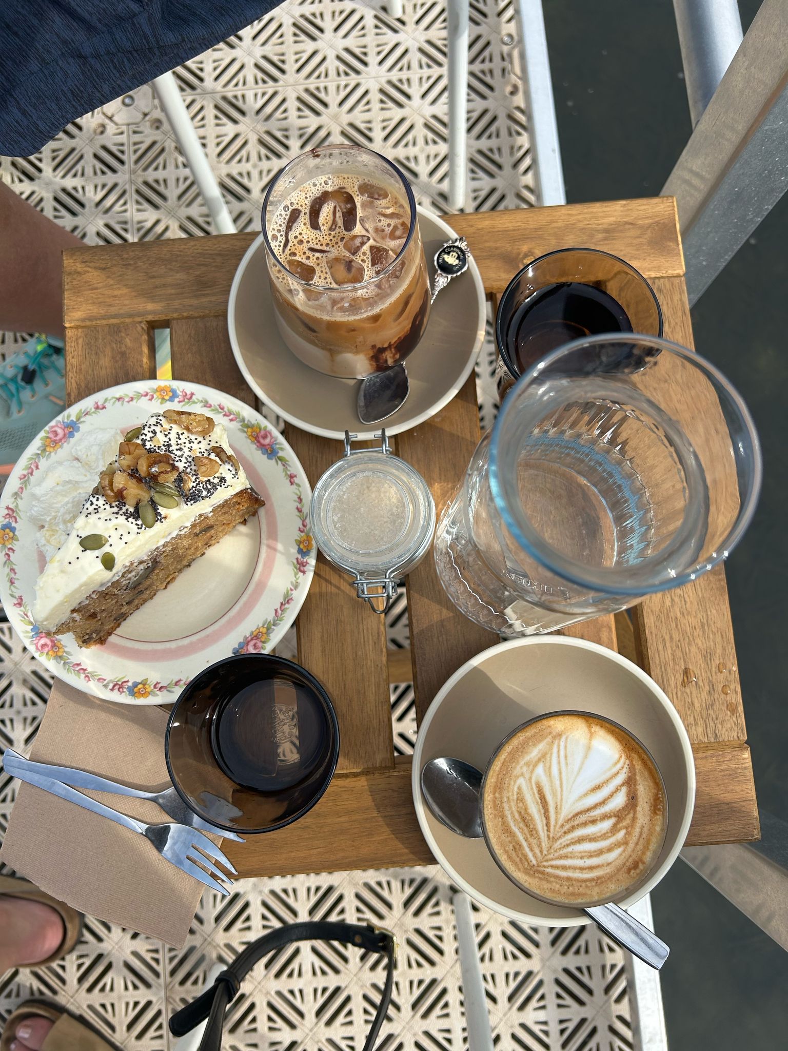 Coffee cup and slice of cake on a table with ocean view from a jetty kiosk